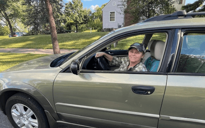 Candace smiling while sitting in her car. 