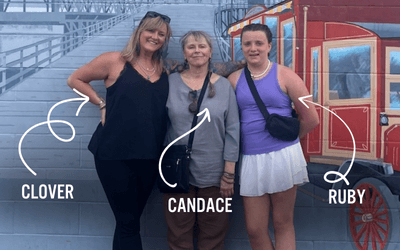 Three generation of women, Candace, Clover, and Ruby, stand together in front of a mural